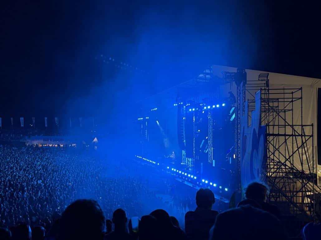 Vue de la scène principale du Venoge Festival 2026 éclairée en bleu devant le public