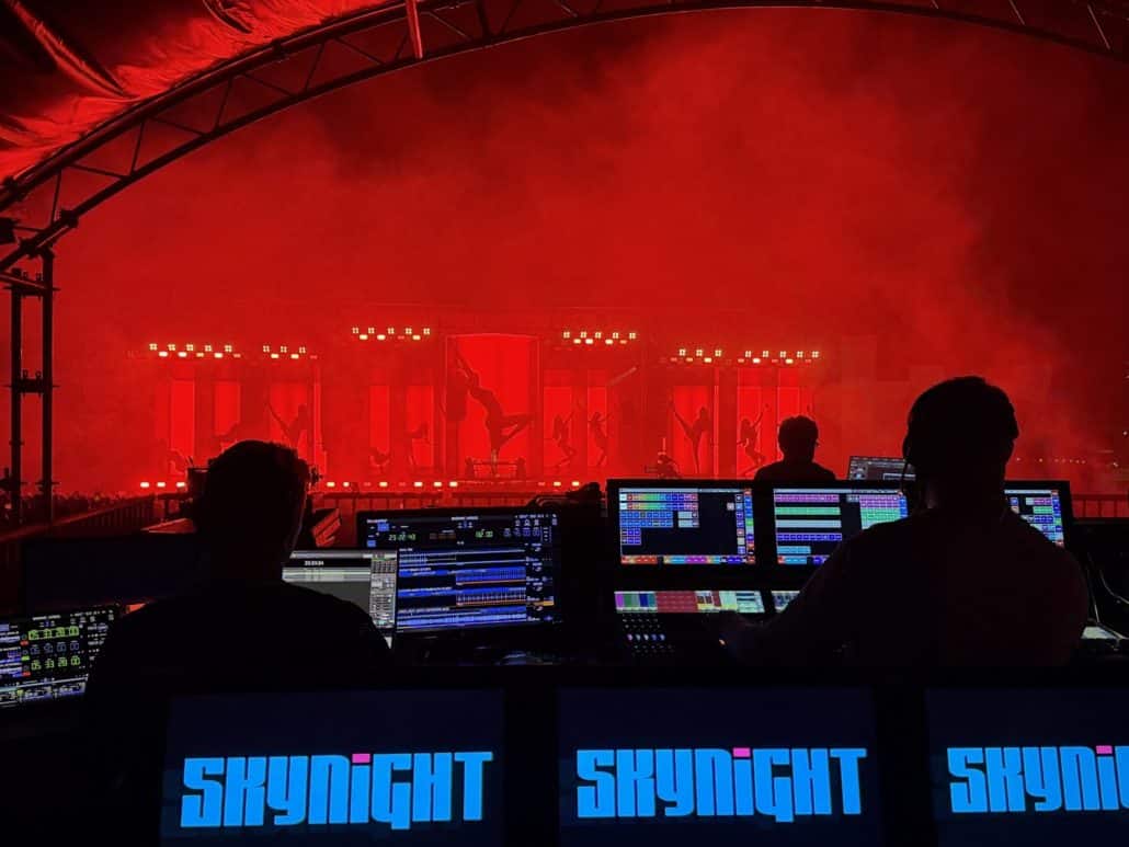 Équipe technique SKYNIGHT en régie pendant un concert avec scénographie lumineuse rouge